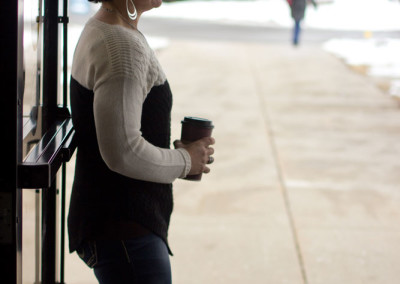 woman holding open front door of church