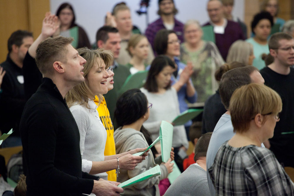 people singing in Sunday worship at church